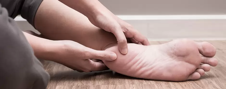 A view of a person holding thier foot pressing the heel