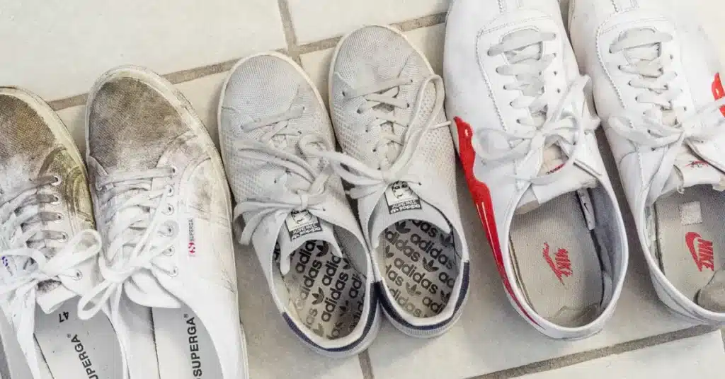 A view of three dirty pairs of white sneakers