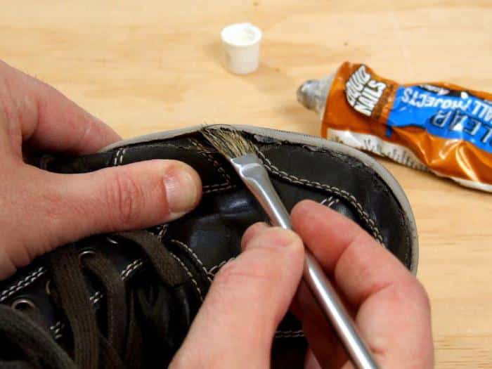 a man applying contact bond on the shoe