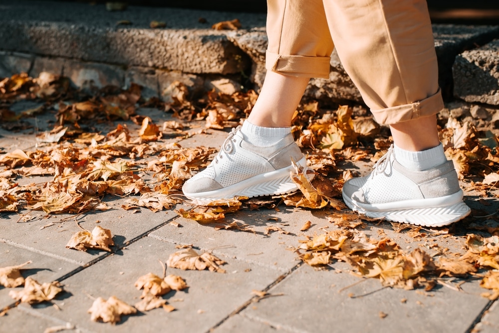 Autumn Hello October Concept Close up Of Female Legs In Sneakers